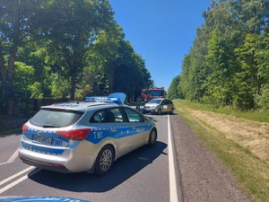 na drodze radiowóz, uszkodzony pojazd osobowy, a za nim wóz strażacki