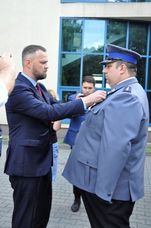 Wicewojewoda Warmińsko – Mazurski Piotr Opaczewski wręcza odznakę policjantowi