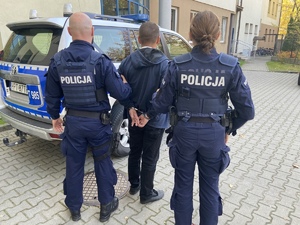 policjanci prowadzą zatrzymanego mężczyznę
