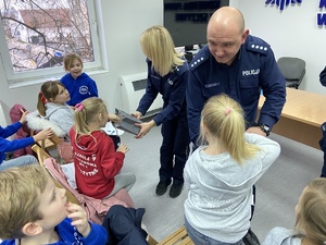 policjanci wręczają dzieciom cukierki