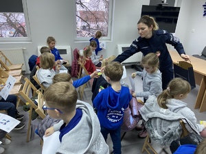 policjantka wręcza dzieciom odblaski