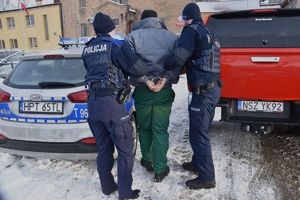 policjanci prowadzą zatrzymanego mężczyznę