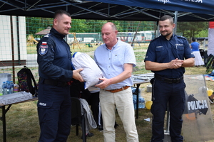 Wójt Gminy Szczytno Sławomir Wojciechowski przekazuje chustę profilaktyczną Komendntowi Powiatowemu Policji w Szczytnie insp. Radosławowi Drach