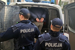 Policjanci doprowadzający zatrzymanego mężczyznę
