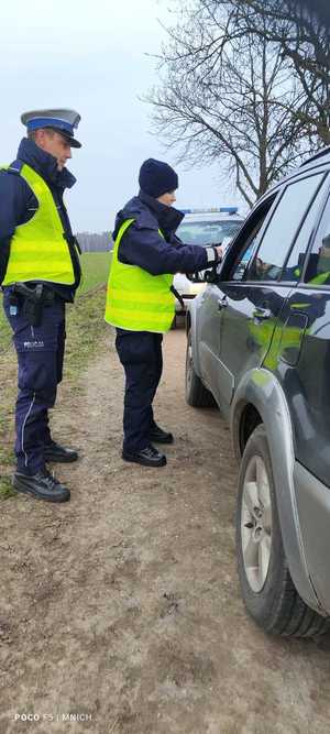 policjanci wykonujący czynności podczas kontroli drogowej