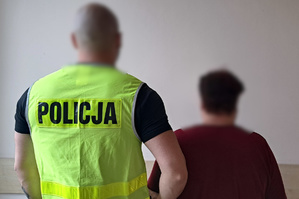 Policjant doprowadzający zatrzymaną kobietę