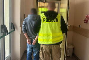 Policjant doprowadzający zatrzymanego 50-latka