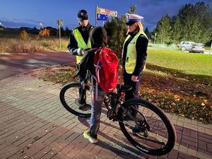 Szczycieńscy policjanci wręczający przechodniom i rowerzystom odblaski