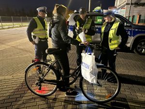 Szczycieńscy policjanci wręczający przechodniom i rowerzystom odblaski