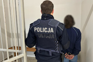 Policjant doprowadzający zatrzymaną kobietę